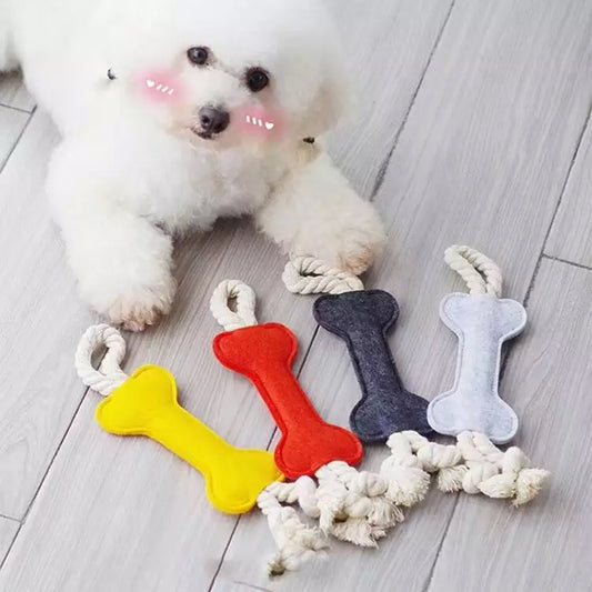 four felt bone shape dog chew toy with rope near a dog