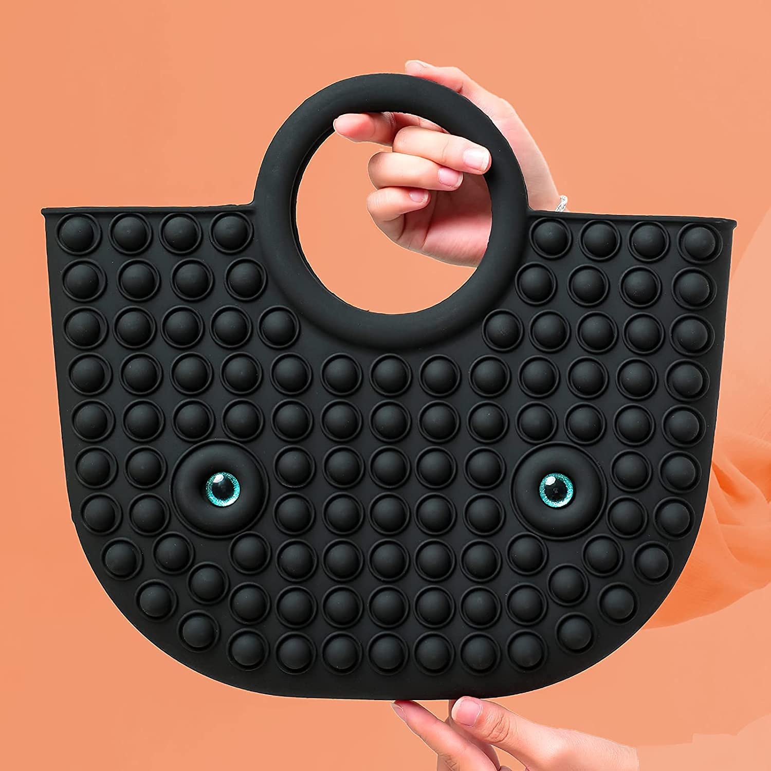 a model showing black pop it fidget handbag with orange background